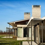 Amusing Sideyard Design of Pavilion Wairau House with Several Dark Colored Metallic Pillars and Soft Grey Colored Concrete Chimney