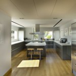 Appealing Grey Kitchen inside the Luxury Resort with Grey Island and Modern Stools on the Hardwood Floor