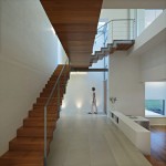 Brilliant Hallway Design of J20 House with White Colored Floor which is Made from Concrete Blocks and Light Brown Colored Wooden Staircase