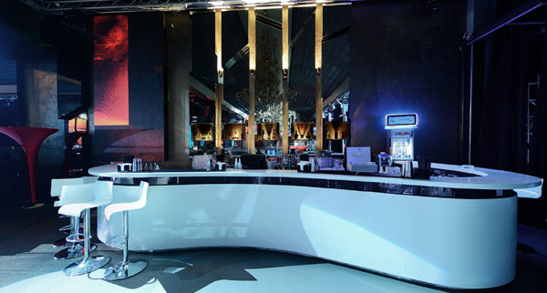 Comfortable White Stools and White Counter inside the Sky Club Romania with Dark Wall and Grey Floor