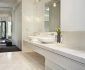 Contemporary Bathroom of the Verdant Avenue House with White Sinks and Long White Vanity under Bubble Lamps