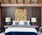 Eccentric Wall Art above Lavish Navy Themed Bed in One Oak Combloux Illuminated by Glaring Pendant Lights above Round Bedside Tables