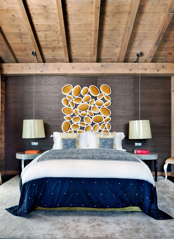 Eccentric Wall Art above Lavish Navy Themed Bed in One Oak Combloux Illuminated by Glaring Pendant Lights above Round Bedside Tables