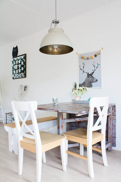 Eclectic Dining Room with Unique Wooden Folding Table near the White Wall and some White Chairs