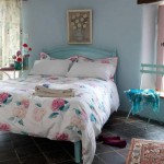 Comfy Beach Bedroom Themes with Blue Bed and Flowery Bedding beside Blue Chair on Stone Flooring