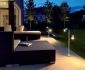 Contemporary Outdoor Lighting Fixtures and Dark Wicker Sofa Chaise in Cozy Patio facing Grass Yard
