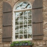 Enchanting Exposed Brick Wall with White Arched Glass Window between Arched Exterior Window Shutters from Oak Material