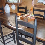 Long Oak Table in Rustic Dining Area with Black Chairs and Farmhouse Style Furniture