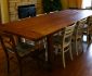 Long Teak Farmhouse Style Dining Table and Classic Wooden Chairs on Laminated Oak Flooring