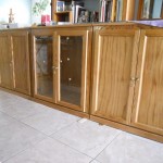 Long Wooden Cabinet with Glass Doors and Upper Bookshelves in Wide Room with Marble Flooring