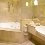 Modern Bathroom Corner Bath Ideas beside Floating Vanity and White Sink under Clear Mirror