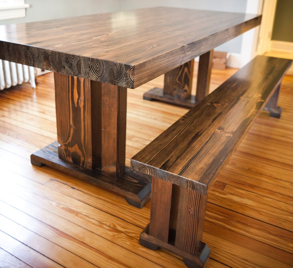 Natural Oak Farmhouse Style Dining Table in Minimalist Dining Area with Long Teak Bench on Hardwood Flooring