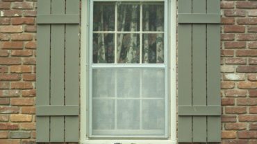 Rustic Exterior Window Shutters in Grey Color for Traditional White Framed Glass Windows