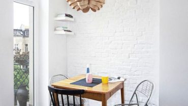 Small Dining Area with Teak Table and Glossy Metal Chairs under Modern Pendant Lighting Fixtures