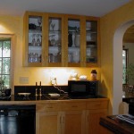 Stylish Black Countertop and Under Cabinet Lamp on Appealing Wooden Cabinet with Glass Doors in Cozy Kitchen