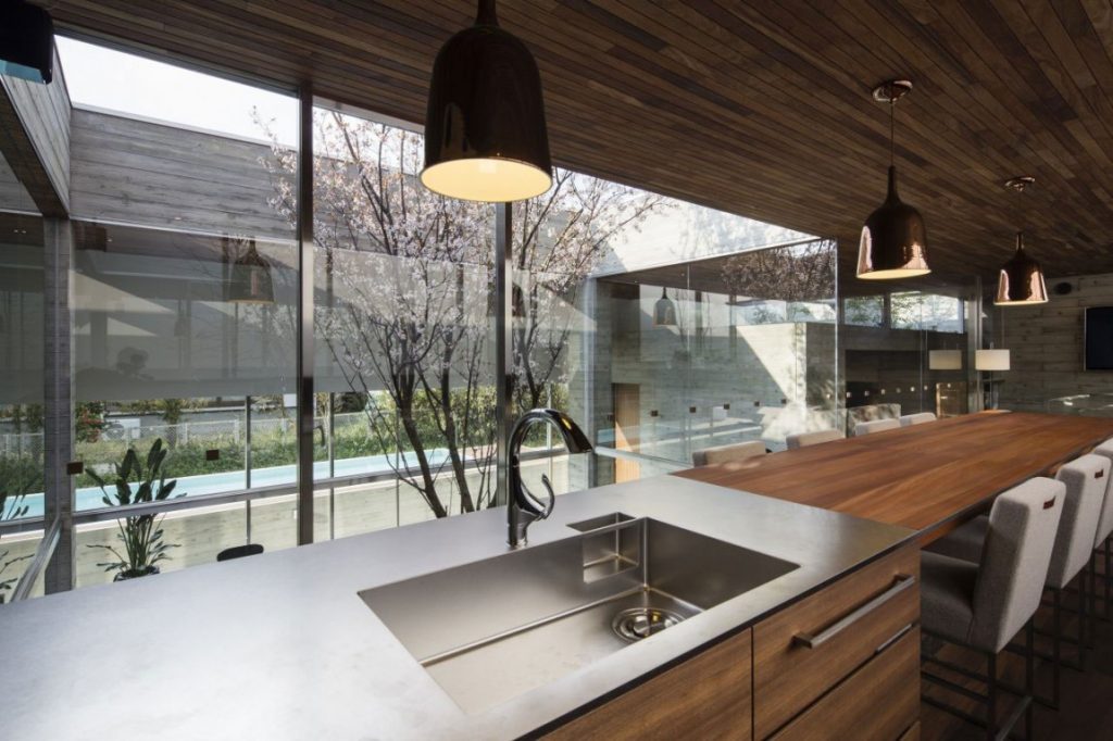Topnotch Long Wooden Dining Room Table Paralleling Island with Sink under Suspended Lamp at Japanese Kitchen Designs