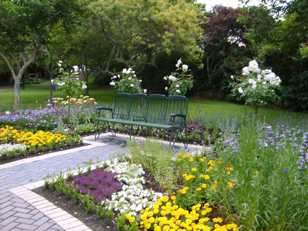 Comfy Bench on Grey Brick Pathway in Beautiful Gardens Decorating Ideas with Colorful Flowers