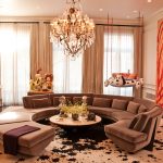 Gorgeous Sitting Room Decor with Curve Sofa and Round Coffee Table under Luxurious Crystal Chandelier