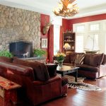 Rustic Stone Wall and Wide Fireplace in Breathtaking Sitting Room Decor with Brown Leather Sofas