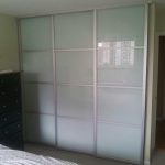 Glossy Glass Sliding Closet Doors with Tiny White Architrave under Large White Ceiling