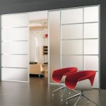 Luminious Large Glass Sliding Closet Doors in Grey Wall Paint facing Red Chair