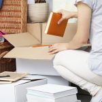 Woman packing house stuff into white boxes