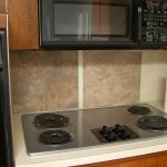 Simple Backsplash Designs for Traditional Kitchen Combined with Wood Wall Storage and Modern Stove