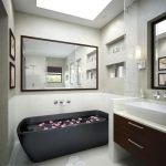 Elegant INterior of Bathroom with Black Sleek Bathtub and arge Mirror Reflecting the Whole Space