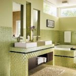 Light Green Bathroom with Sleek Styled Mirror and Tiles Covered Counters and Bathtub