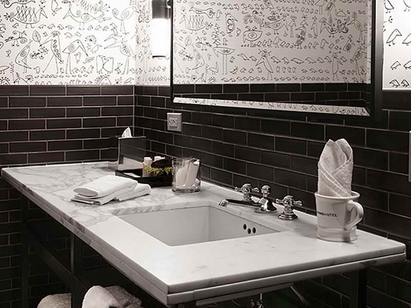 Small Bathroom Sink habing White Marble countertop Set on Black Tiled Bathroom Wall