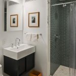 Small Sleek bathroom with Grey Tile SHower Wall and Mounted Single Sink on Wood Storage