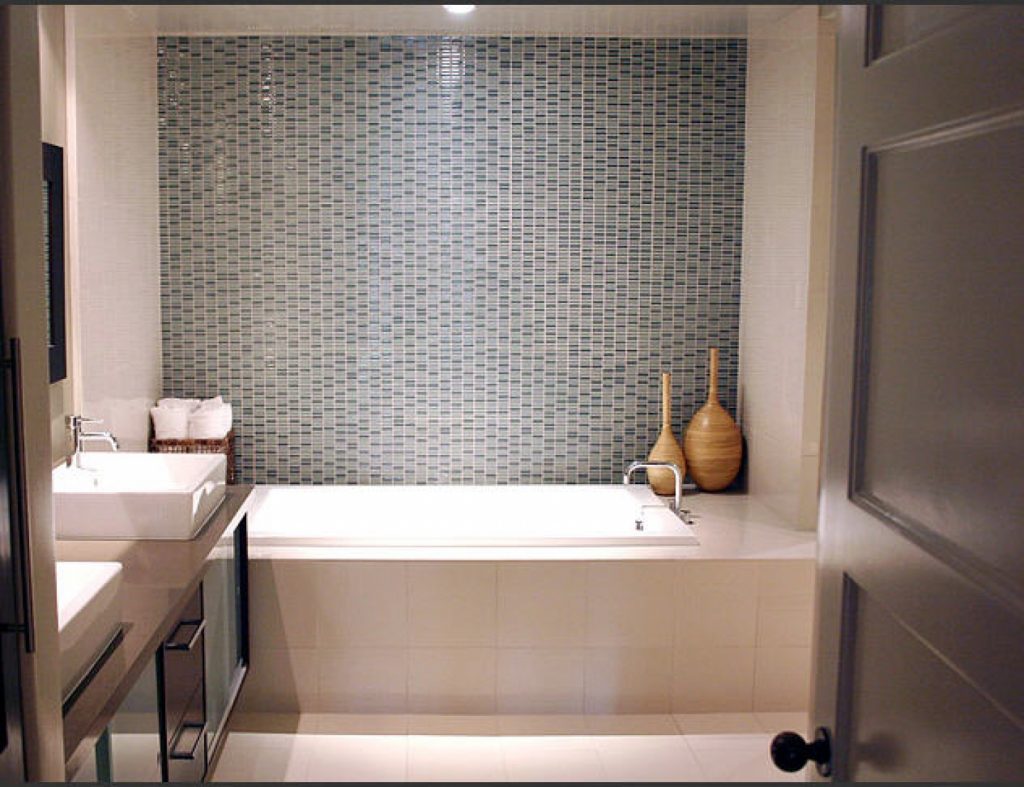 WHite Bathtub in Modern Bathroom having Grey Small TIled Wall on bathing Area